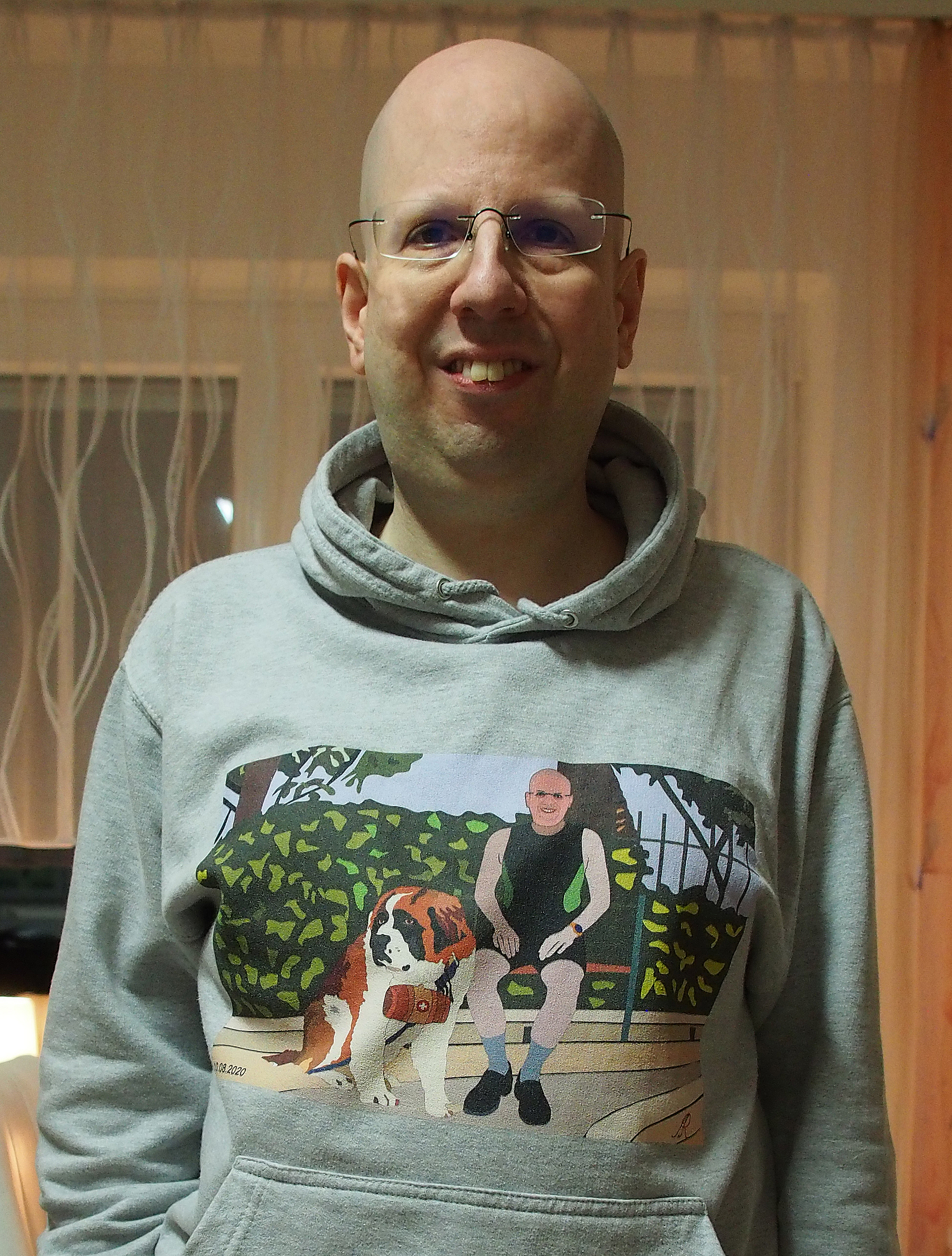 Alexander Reichert mit bedrucktem Kapuzenshirt aus eignener Illustration von Selbstporträt mit Bernhardiner Barry