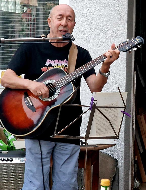 Herr Hauser mit Gitarre und Mikro