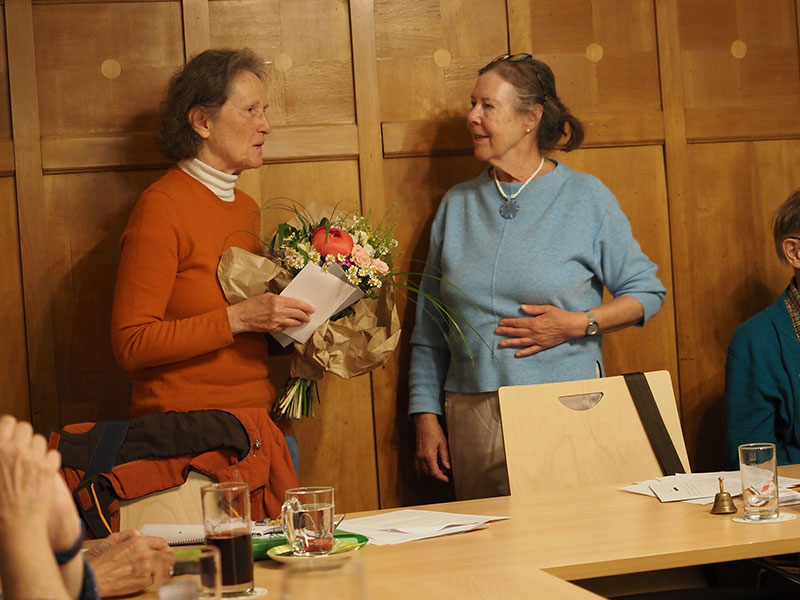 Adelheid hält Blumenstrauß und Briefumschlag in der Hand